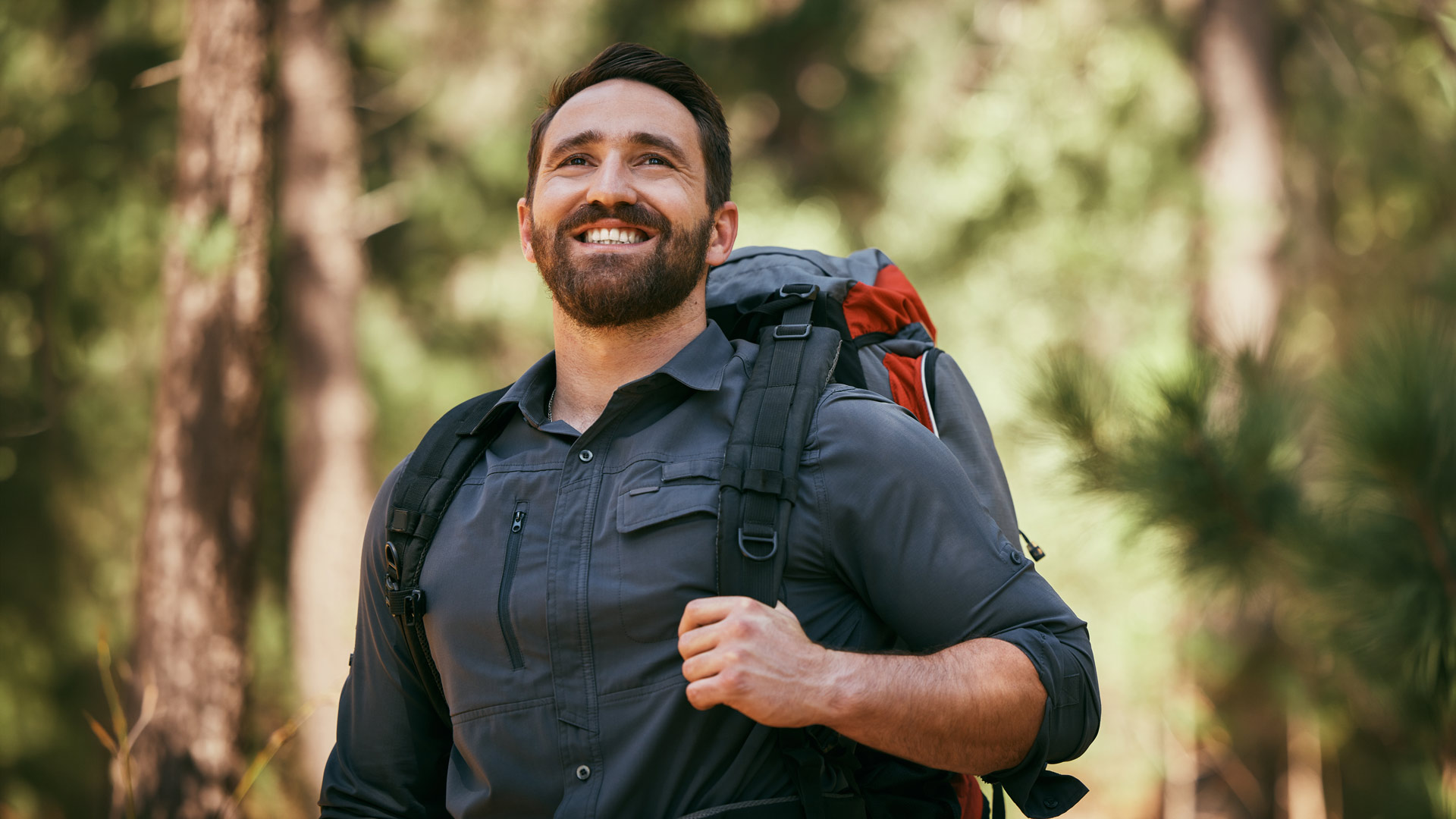 Ein bärtiger Mann im Wald beim Wandern